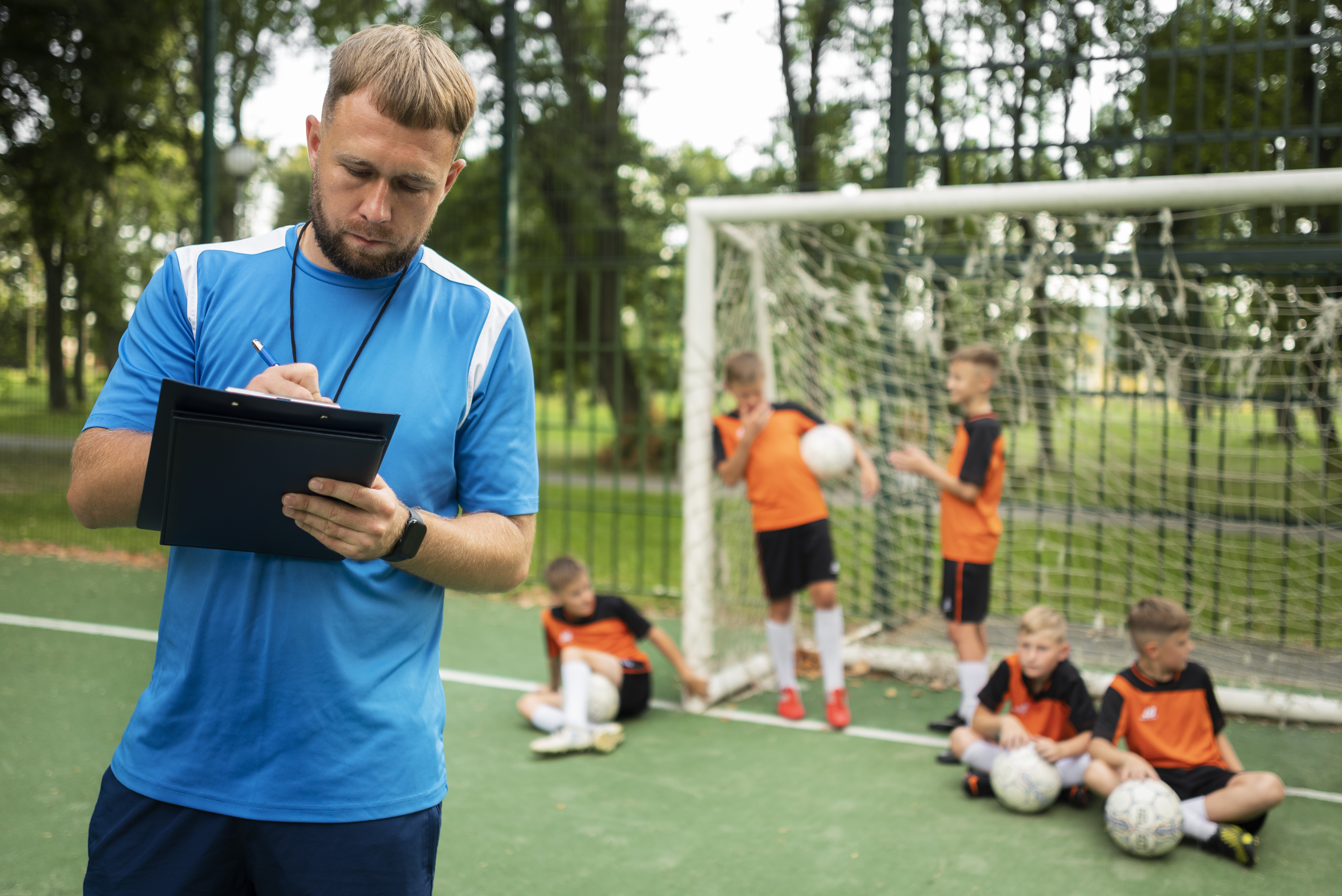 Entrenador de futbol base con sus jugadores